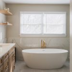 Modern bathroom in Ashburn, VA with gold-accented glass shower and soaking tub