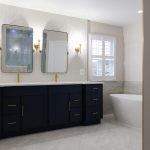 Bathroom remodel in Ashburn, VA featuring black cabinets, gold hardware, and white walls.