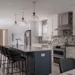 Modern Vienna kitchen with black high chairs, grey walls, and white cabinets