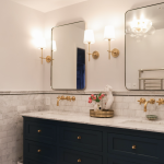 Modern bathroom with gold accents and glass shower door in Alexandria remodel