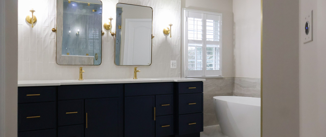 Bathroom remodel in Ashburn, VA featuring black cabinets, gold hardware, and white walls.